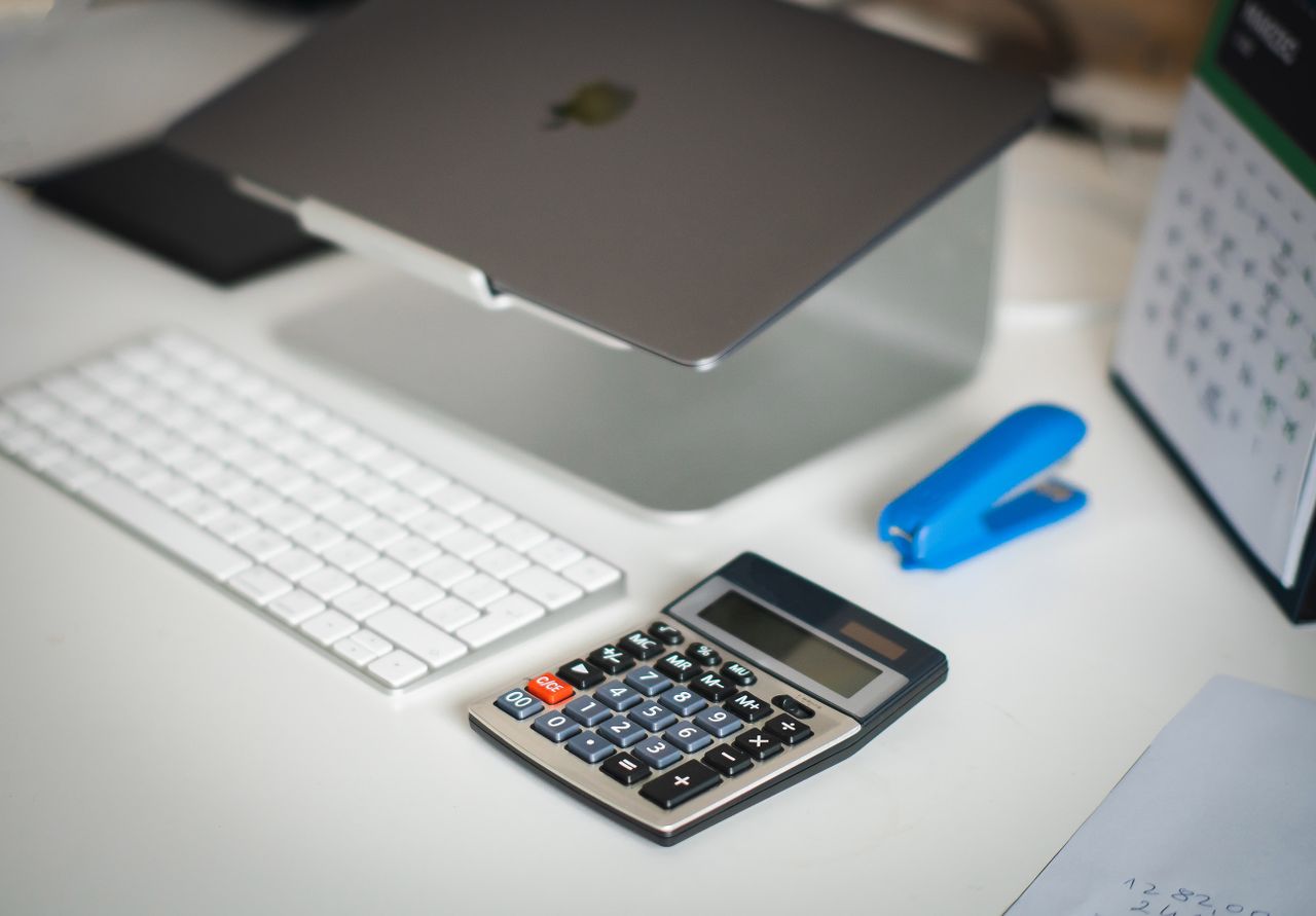 services-04 A tidy office desk featuring a laptop, calculator, keyboard, and calendar for business planning.
