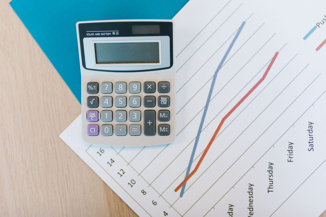 services-01 Top view of calculator and graph paper on office desk, perfect for business themed visuals.